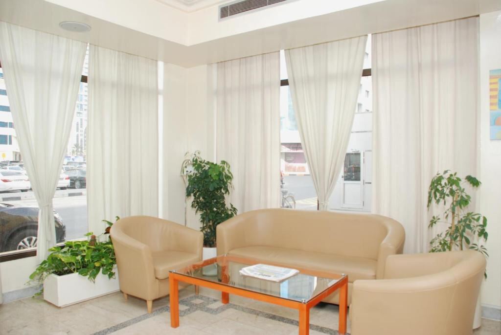 Bright seating lounge with large windows at Al Buhaira Hotel Apartment